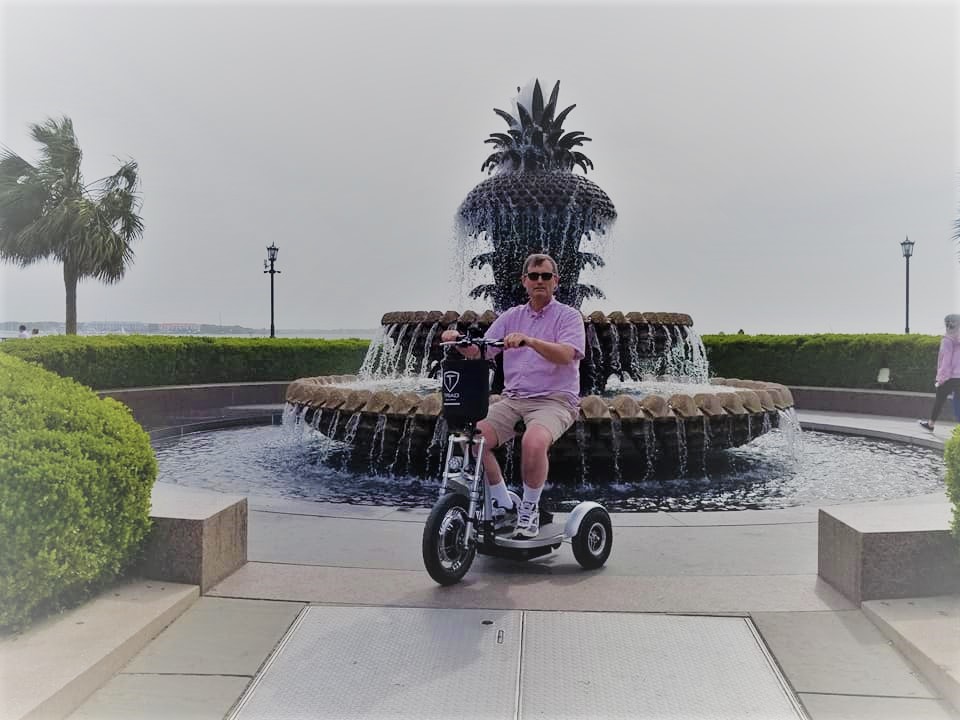 The scooter in front of the pineapple fountain